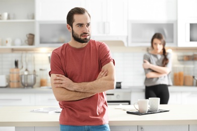 Young couple ignoring each other after having argument in kitchen