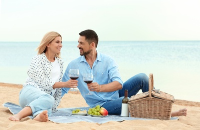 Happy romantic couple having picnic at beach