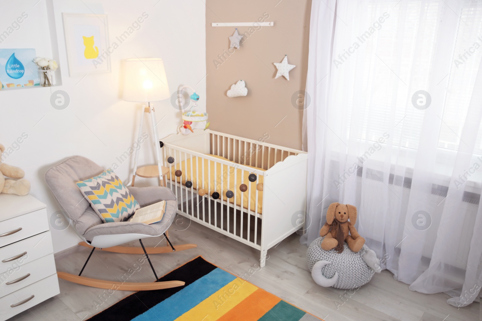 Photo of Cozy baby room interior with crib and rocking chair