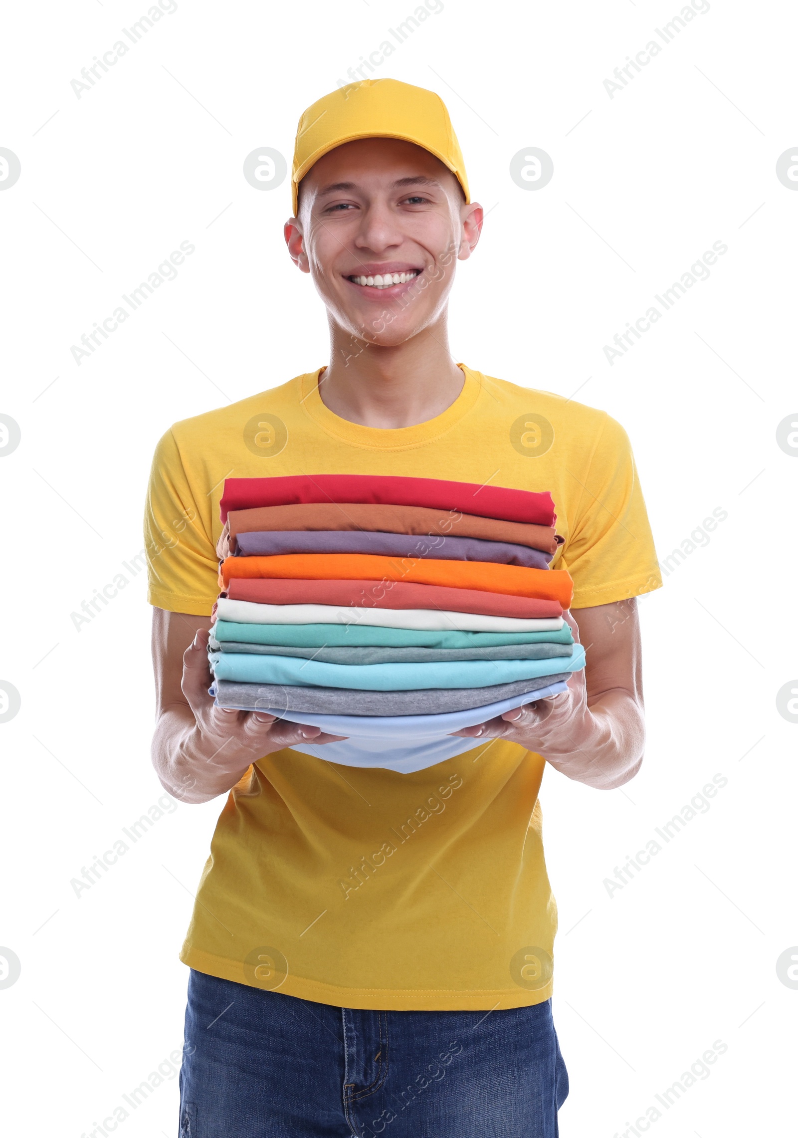 Photo of Dry-cleaning delivery. Happy courier holding folded clothes on white background