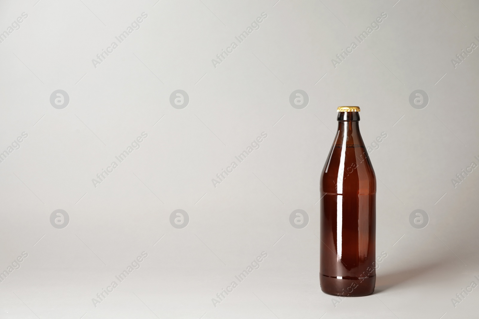 Photo of Bottle of beer on grey background. Space for text