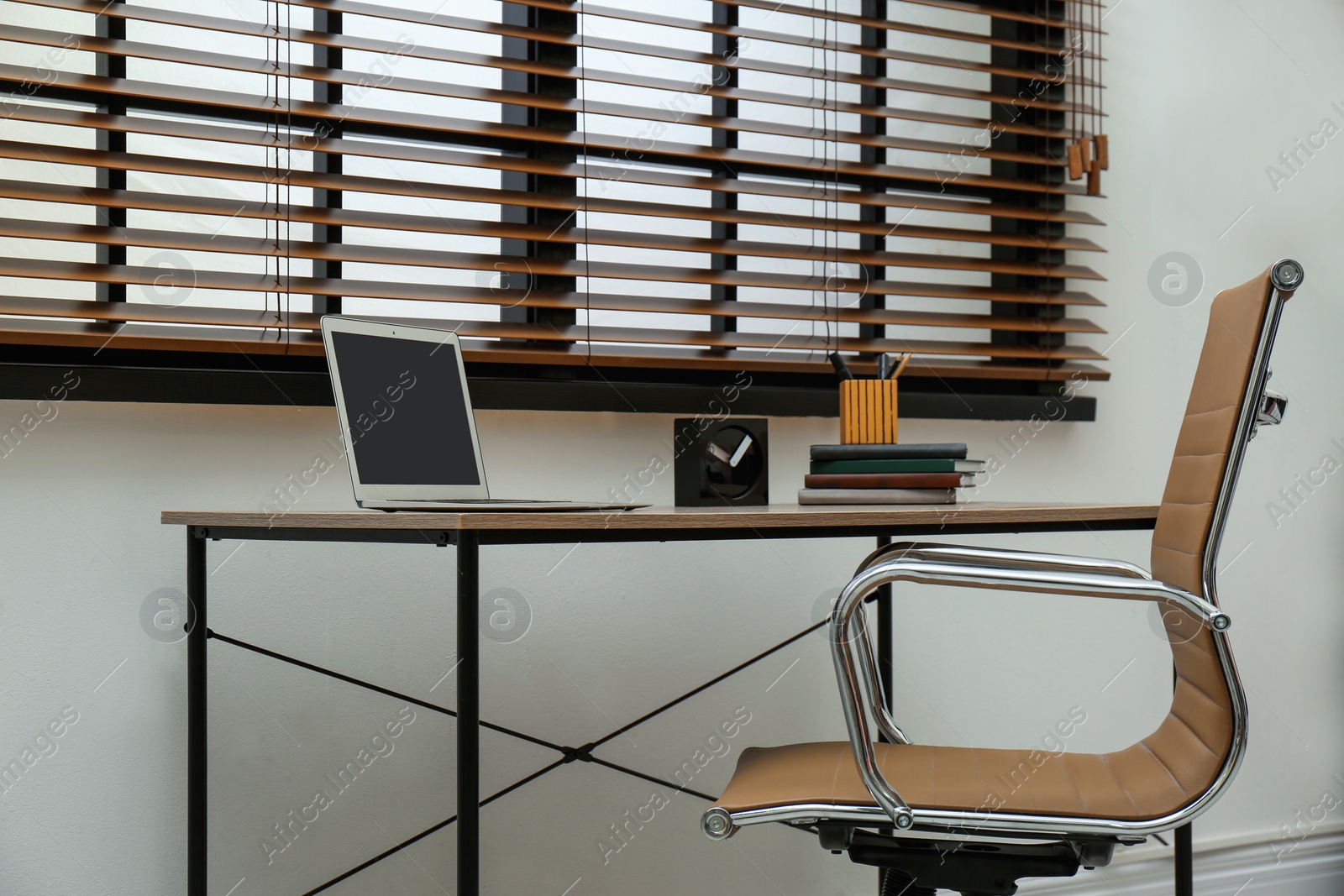 Photo of Stylish workplace interior with modern office chair