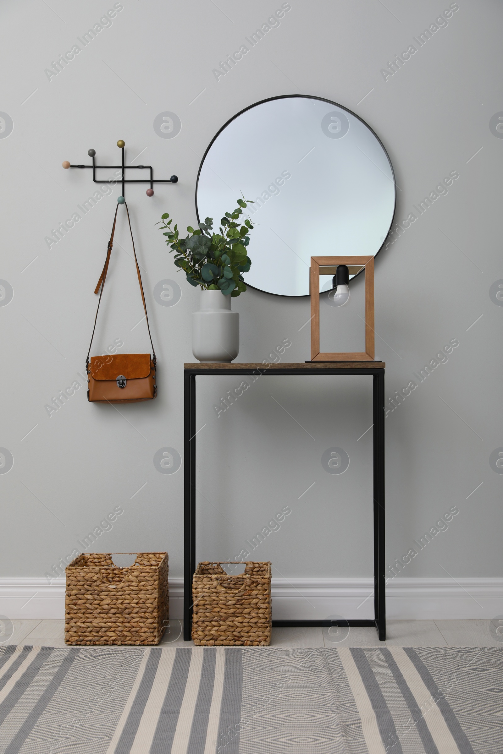 Photo of Light hallway with stylish console table and mirror. Interior design