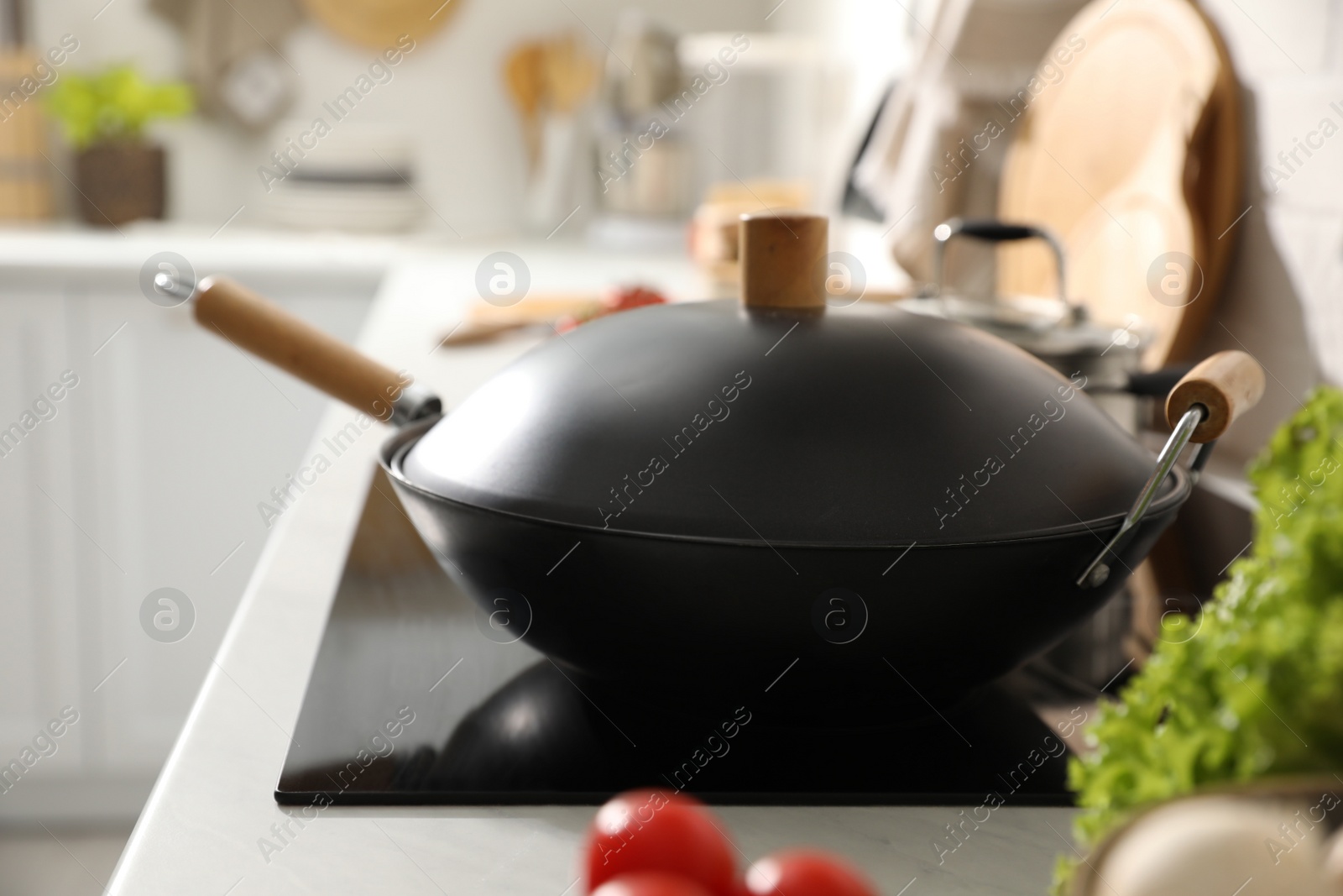 Photo of Frying pan with lid on cooktop in kitchen