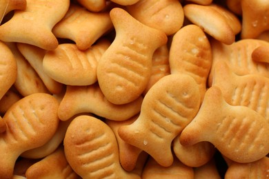 Photo of Delicious goldfish crackers as background, closeup view