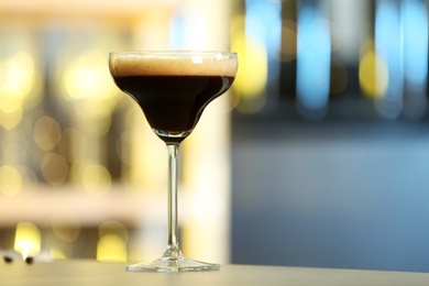 Photo of Fresh alcoholic Martini Espresso cocktail on bar counter, space for text