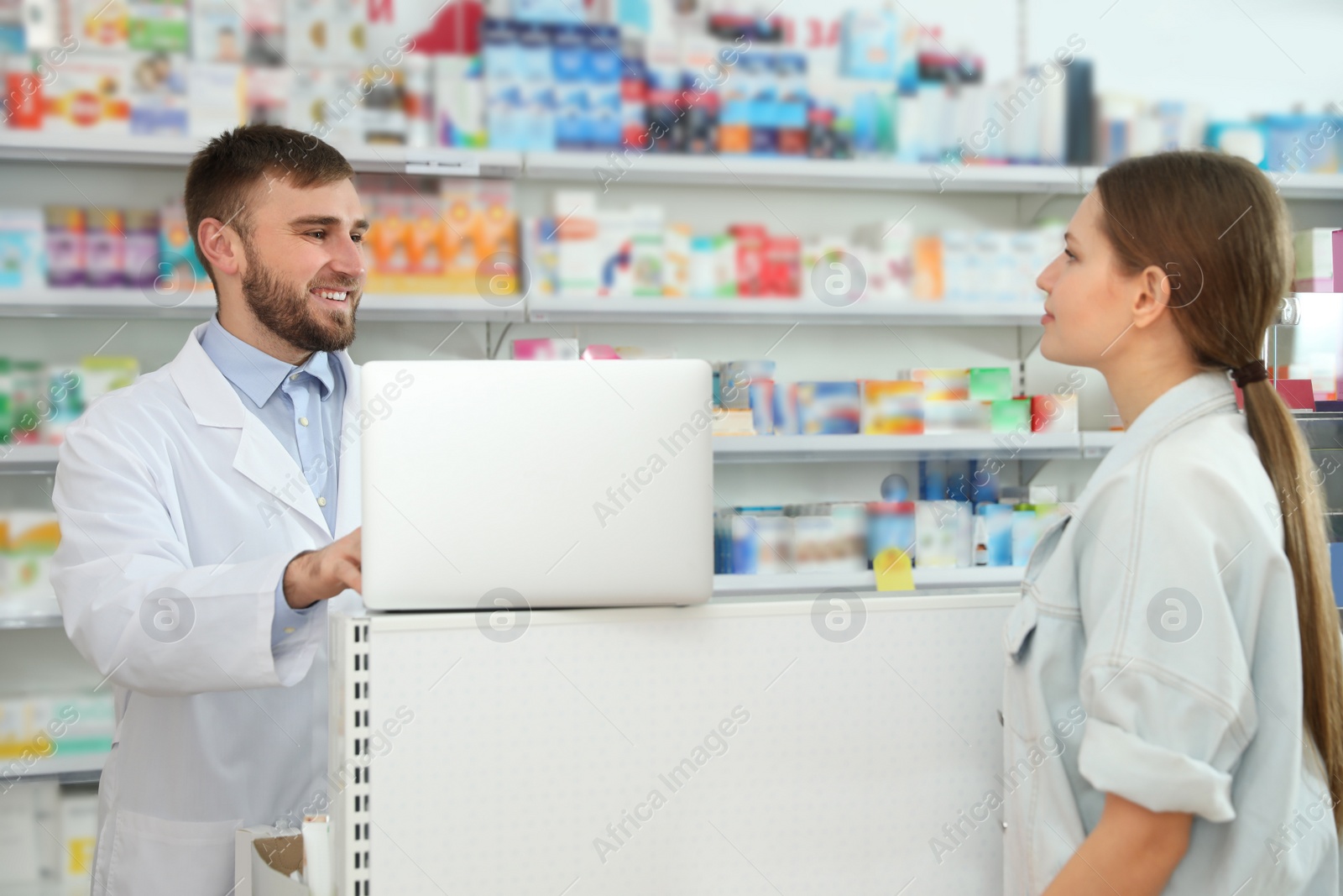 Image of Professional pharmacist working with customer in modern drugstore