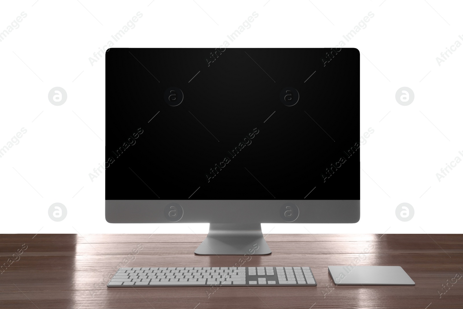 Photo of Modern computer with blank monitor screen and peripherals on wooden table against white background