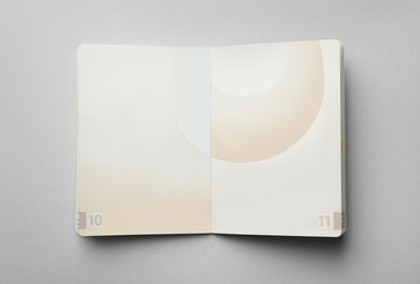 Photo of Open passport on grey background, top view