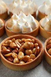 Many different tartlets on light grey table, closeup. Tasty dessert