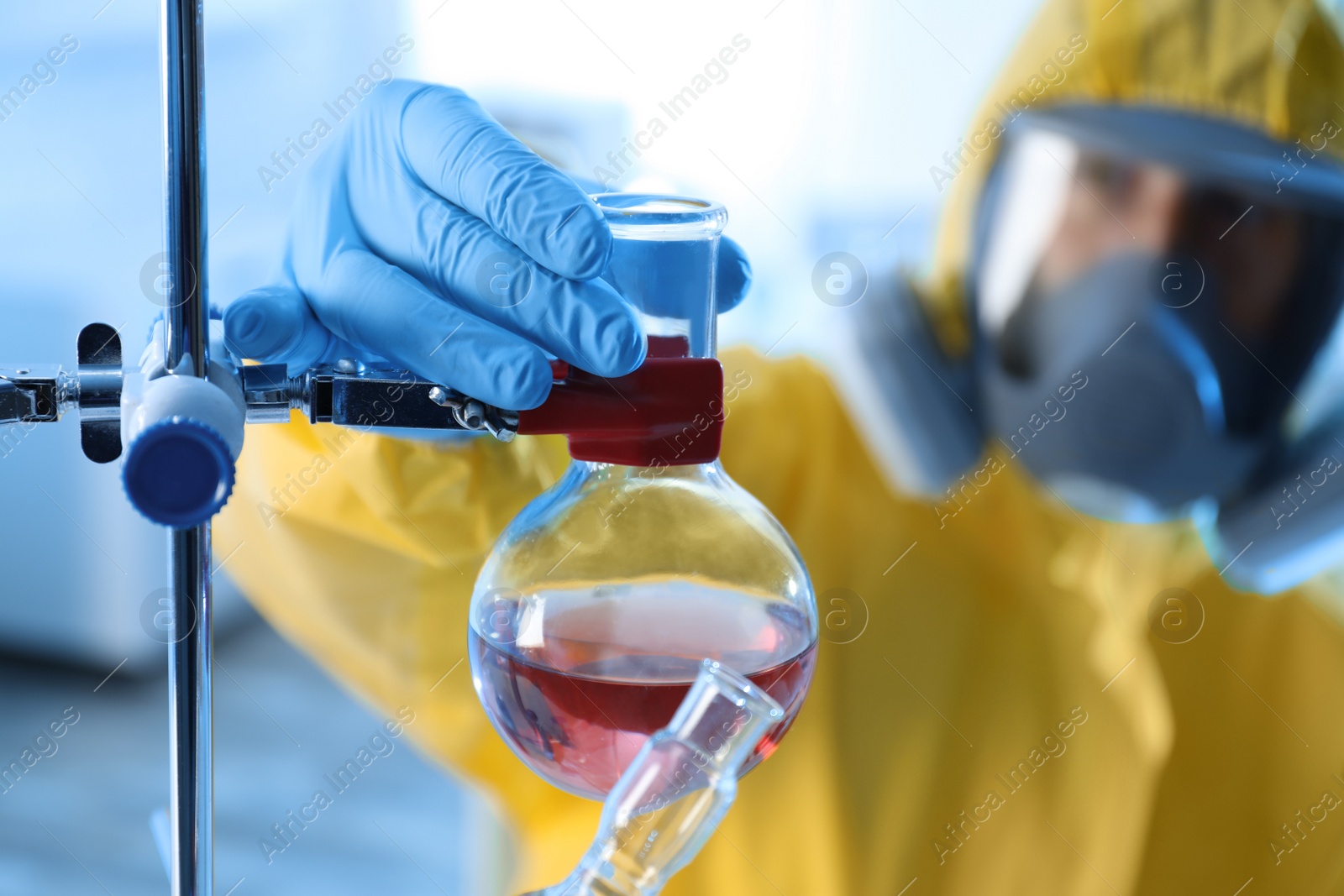Photo of Scientist in chemical protective suit working at laboratory, focus on hand. Virus research