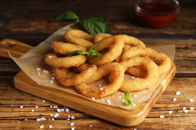 Delicious onion rings on wooden table, closeup