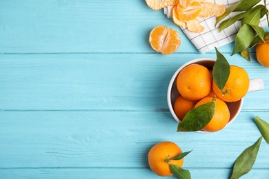 Flat lay composition with fresh ripe tangerines and space for text on wooden background