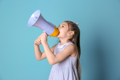 Photo of Cute little girl with megaphone on color background