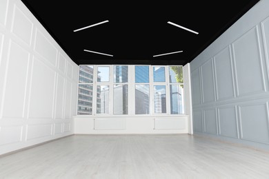 Photo of Empty office room with black ceiling and windows. Interior design