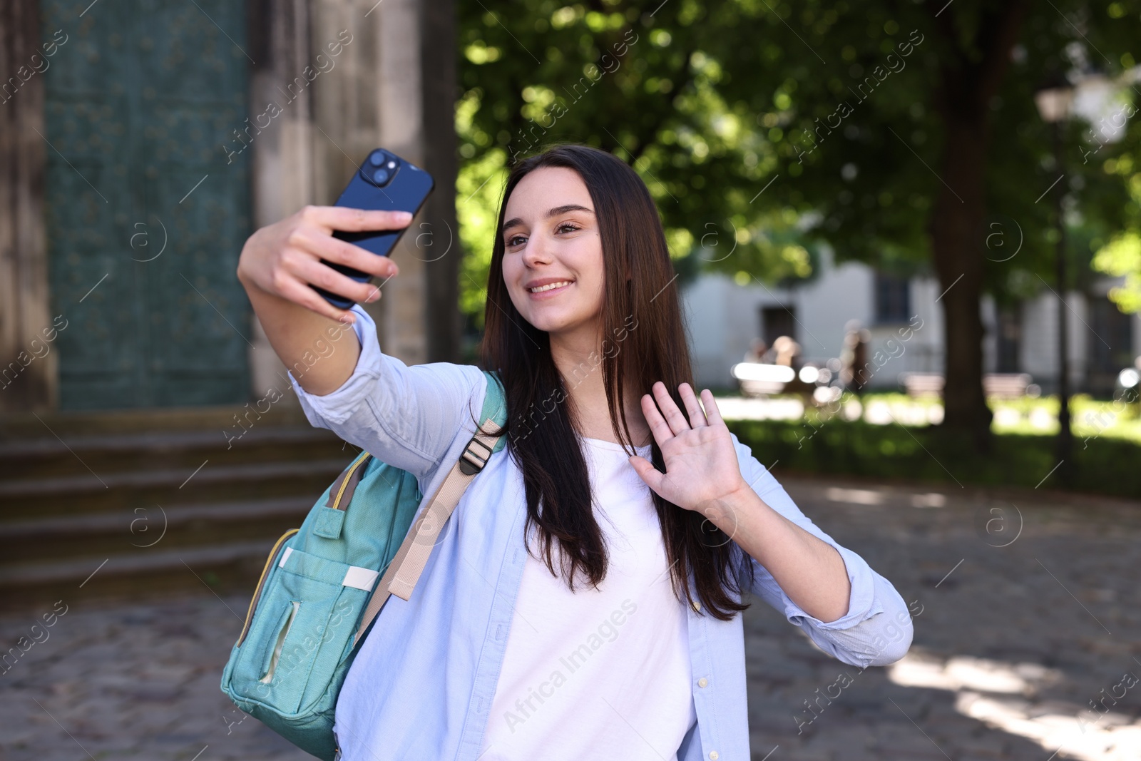 Photo of Beautiful travel blogger with smartphone streaming outdoors