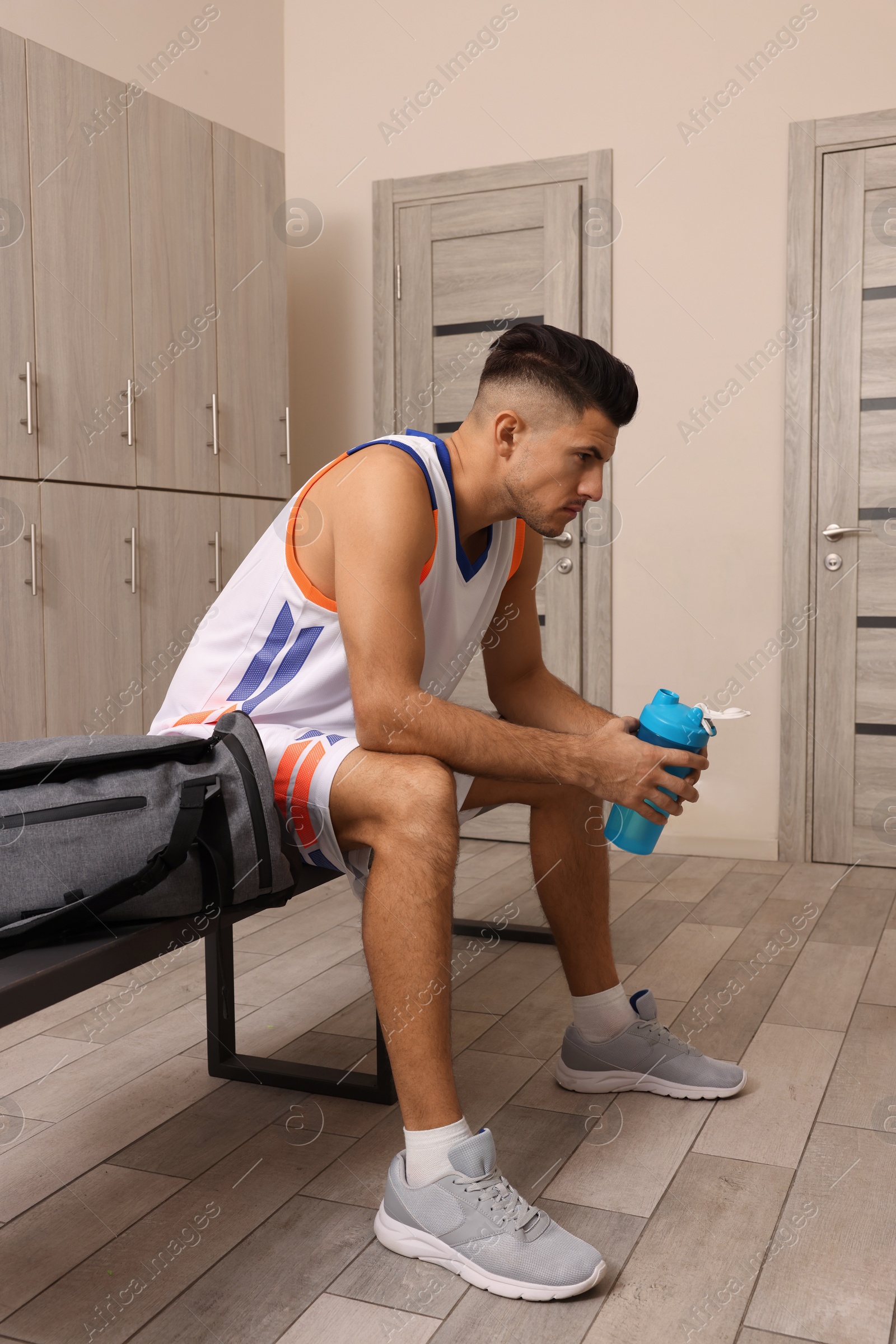 Photo of Handsome man with shaker in locker room