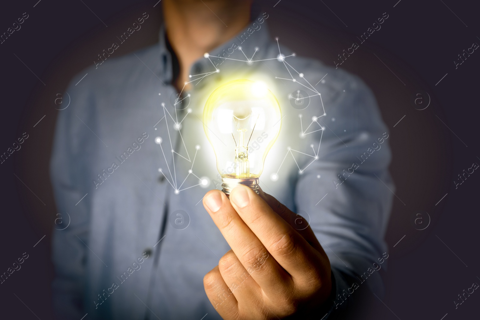 Image of Glow up your ideas. Man holding light bulb on dark background, closeup