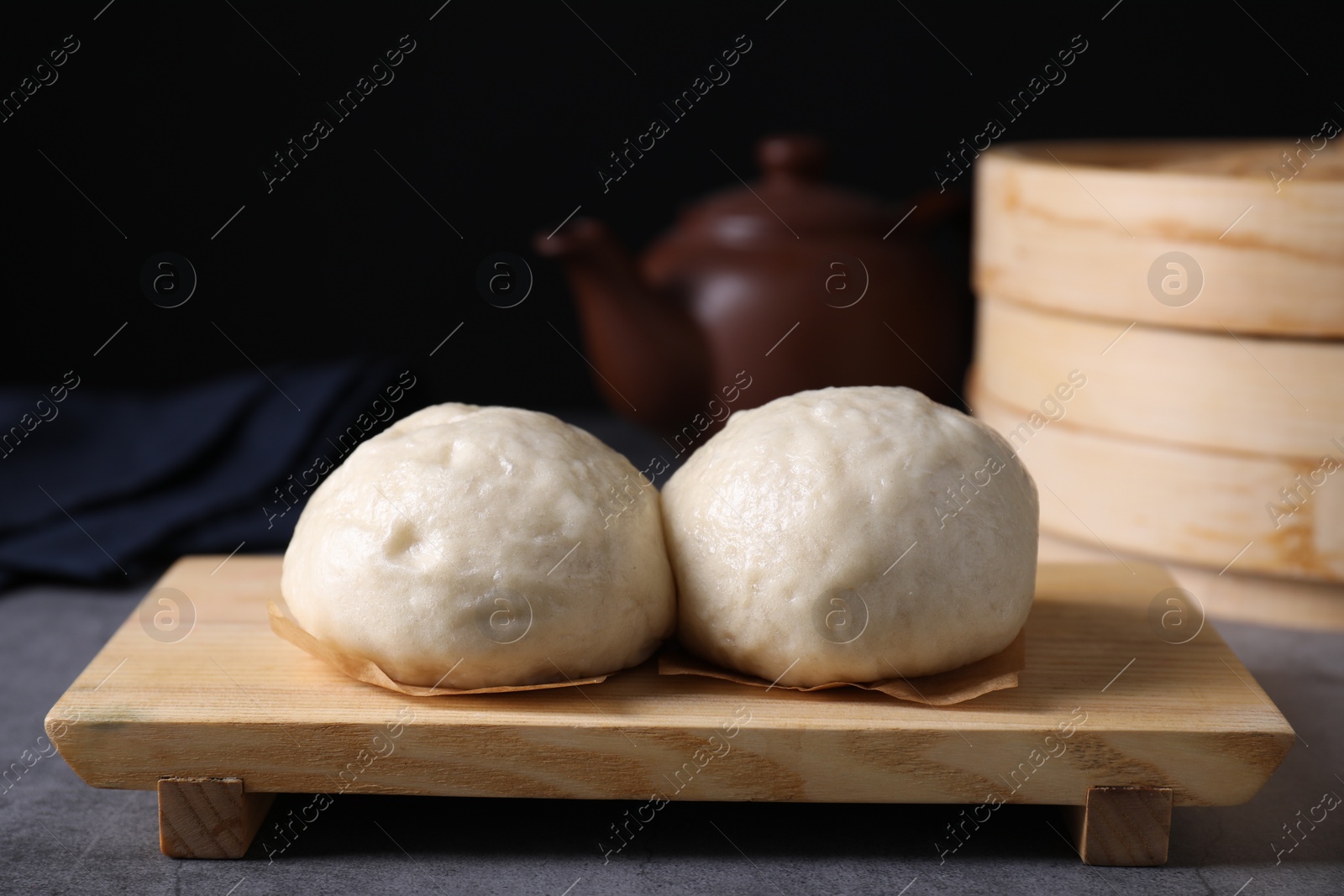 Photo of Delicious Chinese steamed buns on grey textured table, closeup