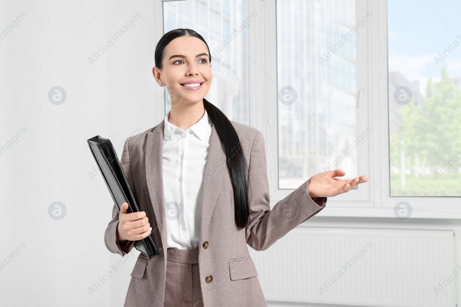 Photo of Beautiful real estate agent with documents indoors