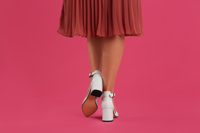 Photo of Woman wearing stylish shoes on pink background, closeup