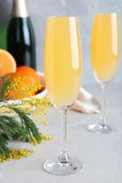 Glasses of Mimosa cocktail on light table