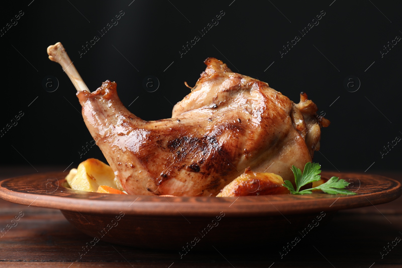 Photo of Tasty cooked rabbit meat with potatoes on table, closeup