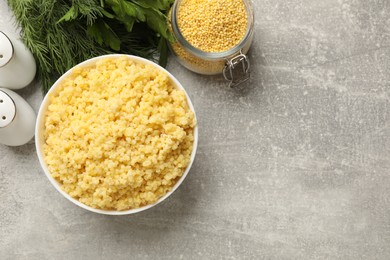 Photo of Tasty millet porridge on grey textured table, flat lay. Space for text