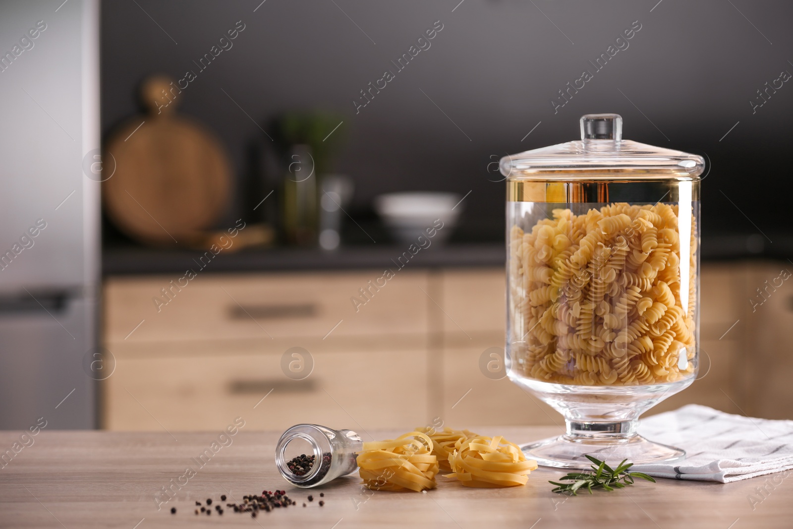 Photo of Raw pasta on wooden table in modern kitchen