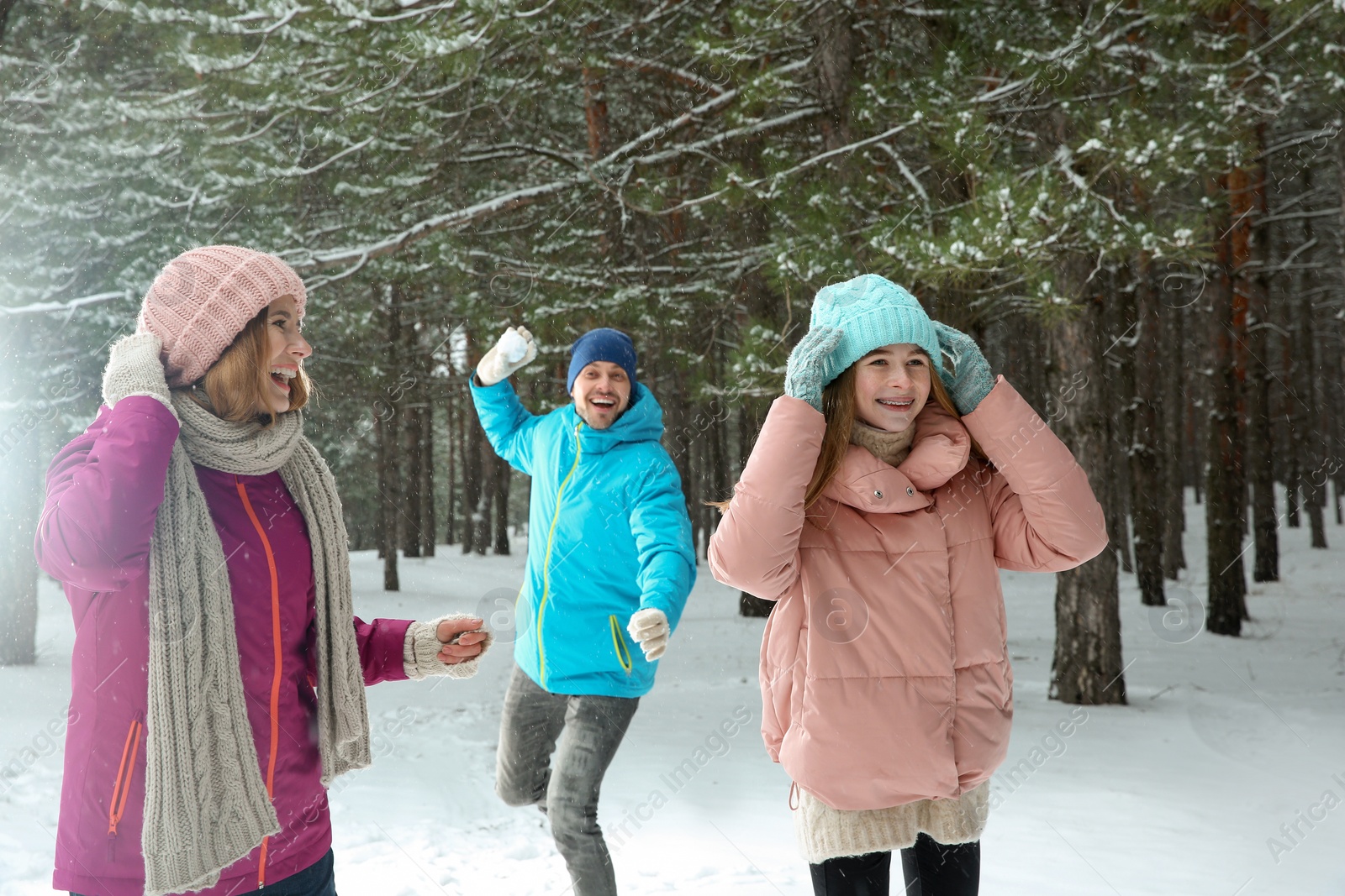 Photo of Happy family playing snowballs in winter forest