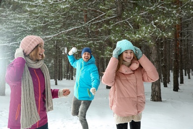 Photo of Happy family playing snowballs in winter forest