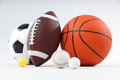 Many different sports balls on light gray background