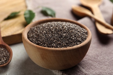 Photo of Chia seeds in bowl on table, closeup