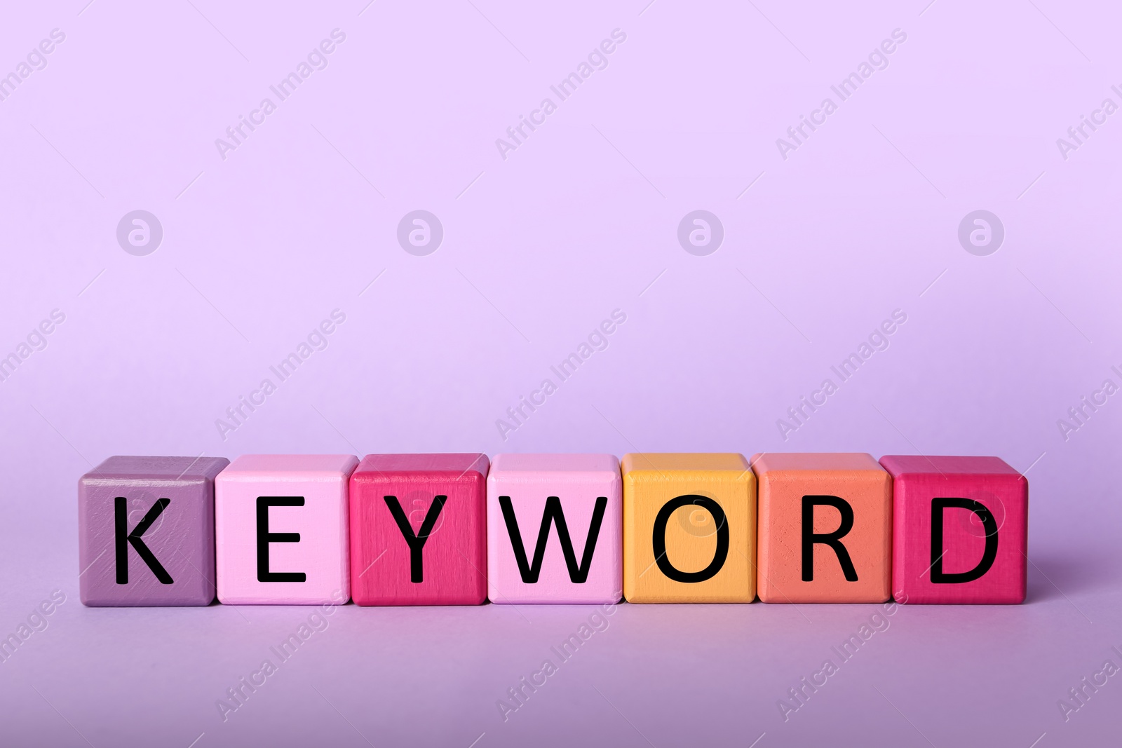 Photo of Colorful cubes with word KEYWORD on lilac background