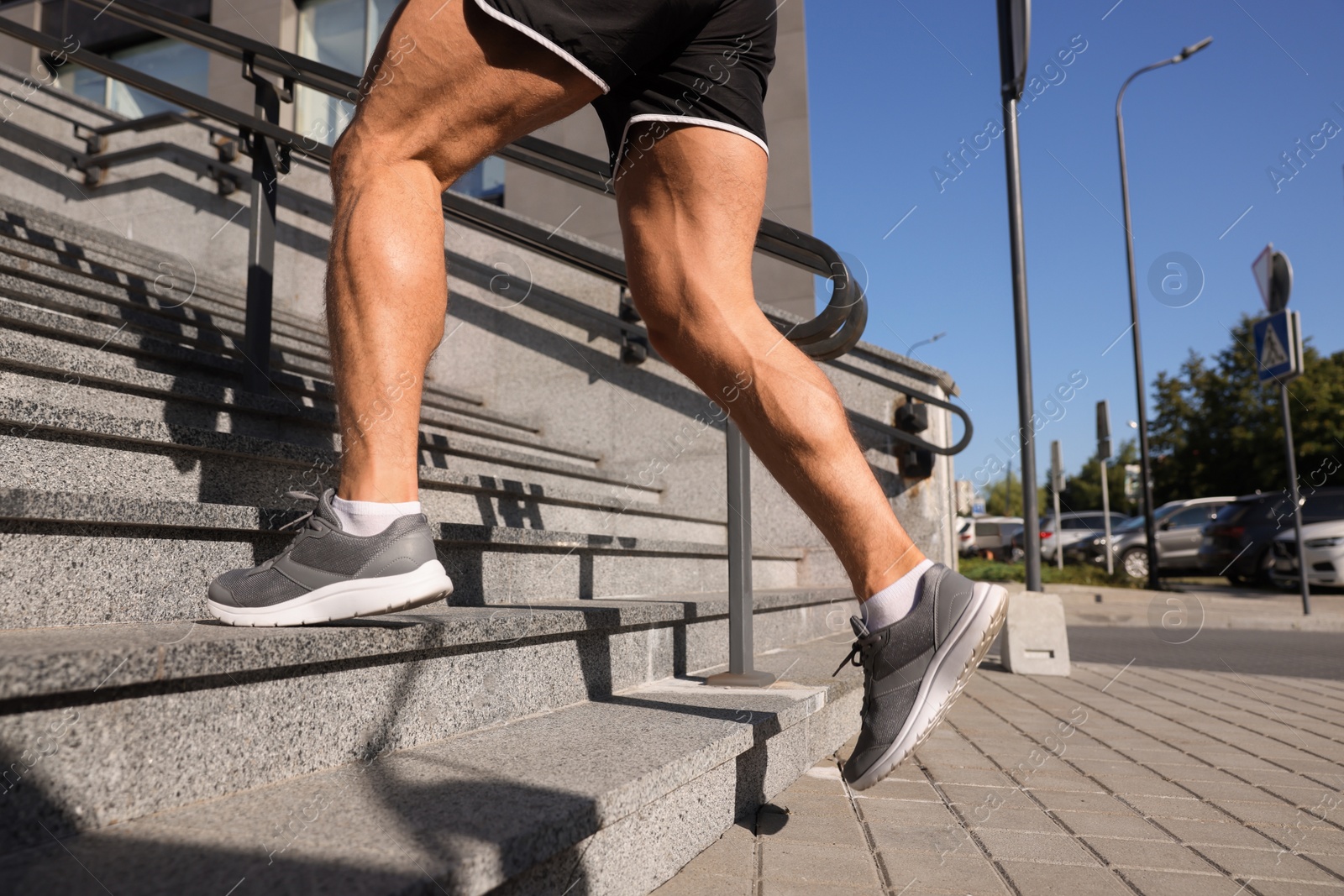 Photo of Man running up stairs outdoors on sunny day, closeup. Space for text