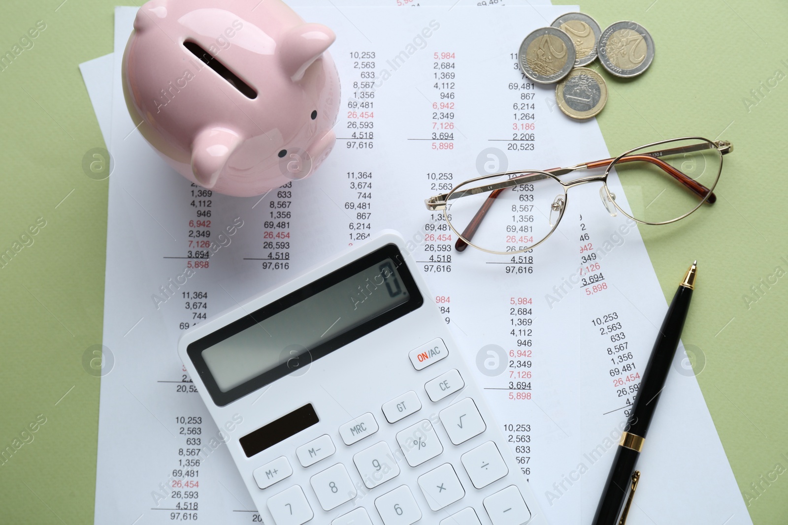 Photo of Flat lay composition with piggy bank and calculator on green background