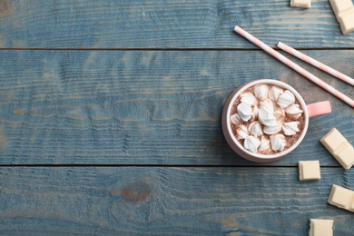 Photo of Cup of chocolate milk with marshmallows on wooden background, flat lay. Space for text