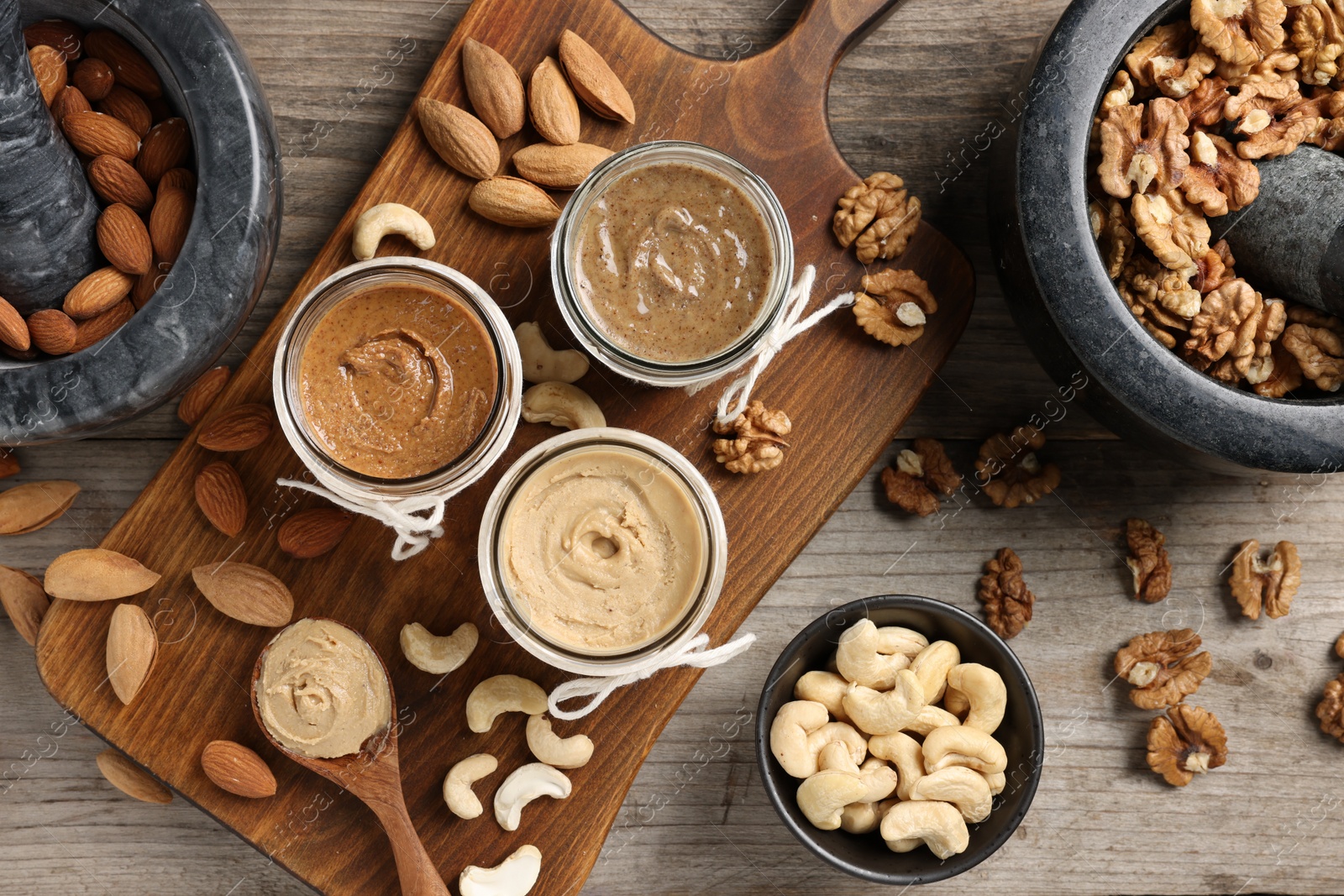 Photo of Making nut butters from different nuts. Fat lay composition on wooden table