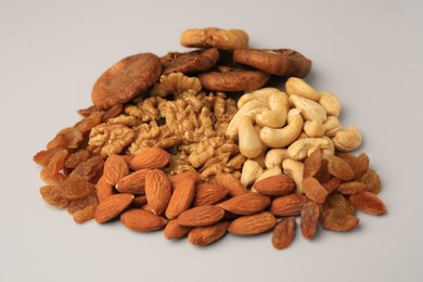 Different tasty nuts and dried fruits on beige background