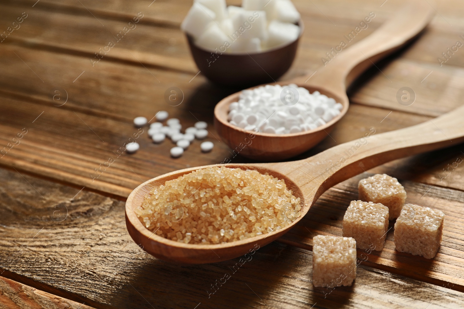 Photo of Different types of sugar on wooden table