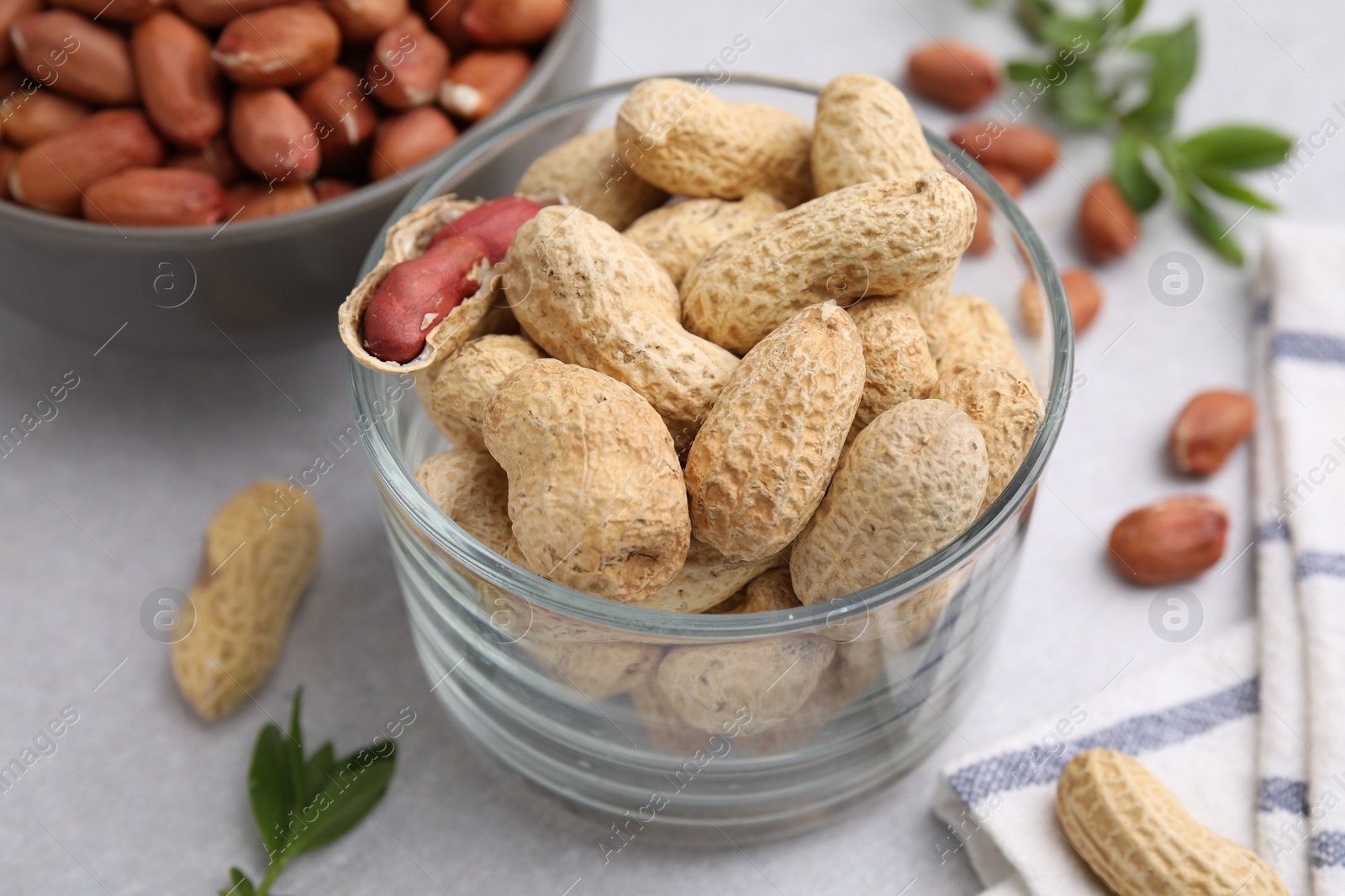 Photo of Fresh unpeeled peanuts on grey table, closeup