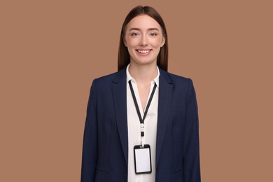 Woman with blank badge on light brown background