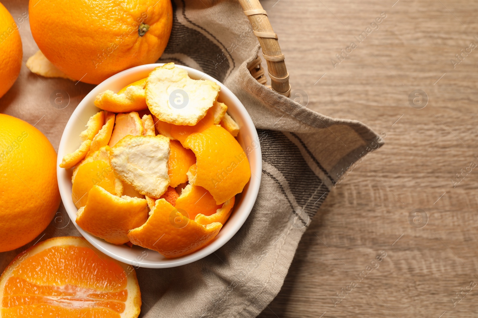 Photo of Orange peels preparing for drying and fresh fruits on wooden table, top view