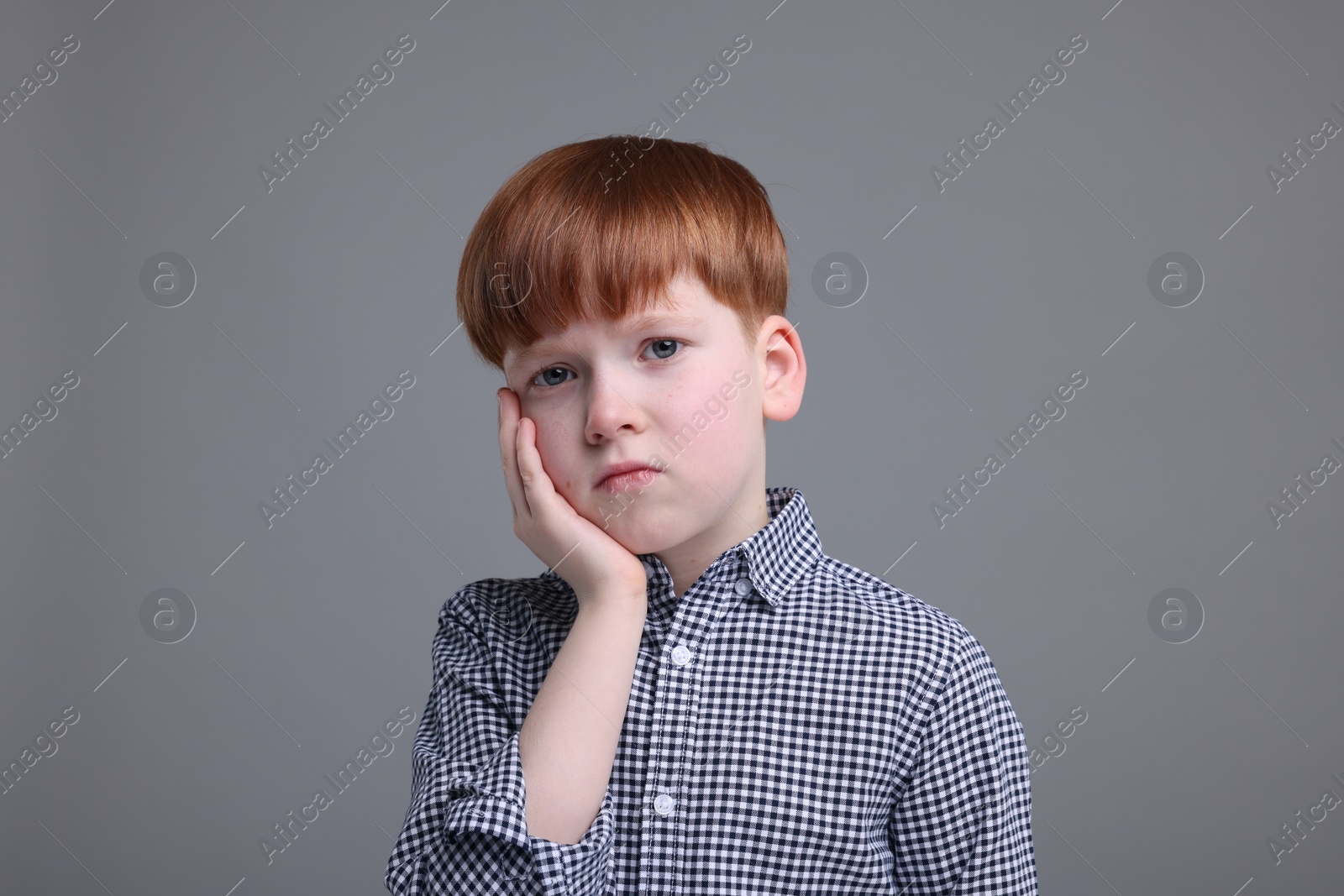 Photo of Portrait of sad little boy on grey background