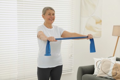 Senior woman doing exercise with fitness elastic band at home