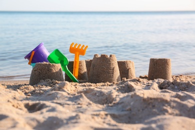 Photo of Little sand figures and plastic toys on beach near sea