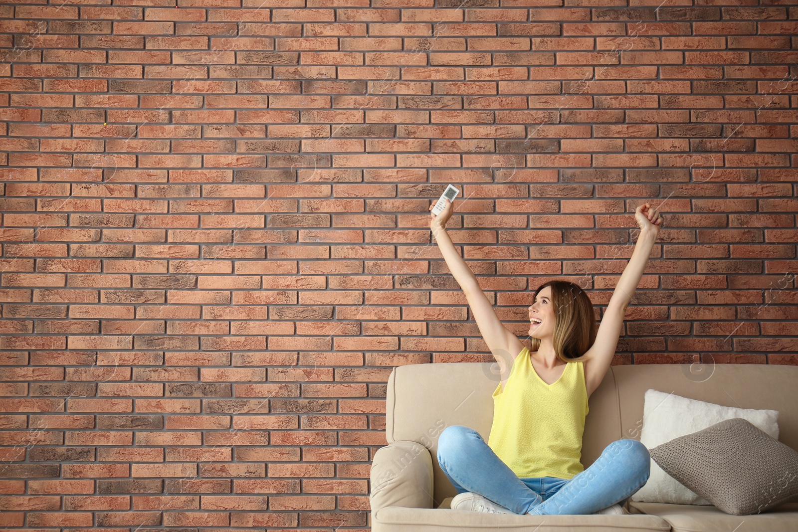 Photo of Happy woman with air conditioner remote at home