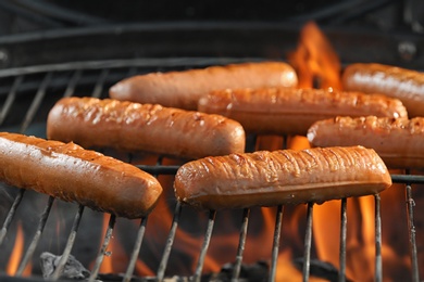 Photo of New modern barbecue grill with tasty sausages, closeup