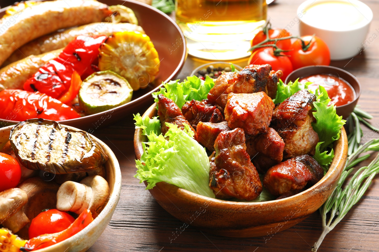 Photo of Delicious meal served for barbecue party on wooden table