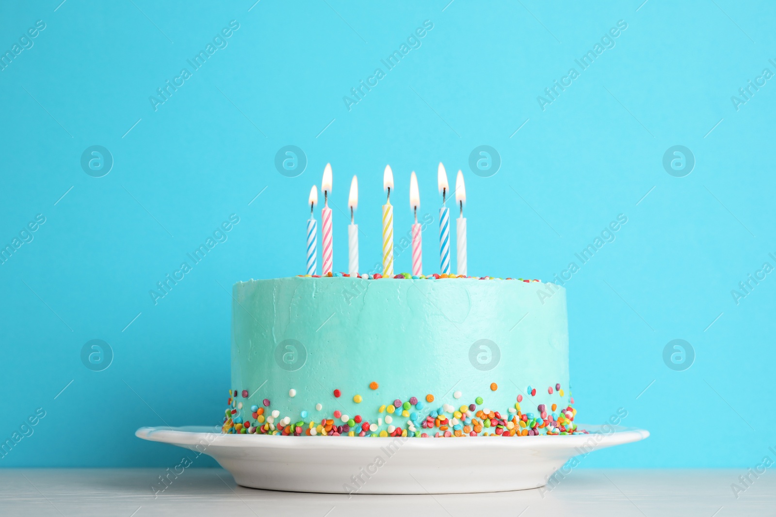 Photo of Fresh delicious birthday cake with candles on table against color background